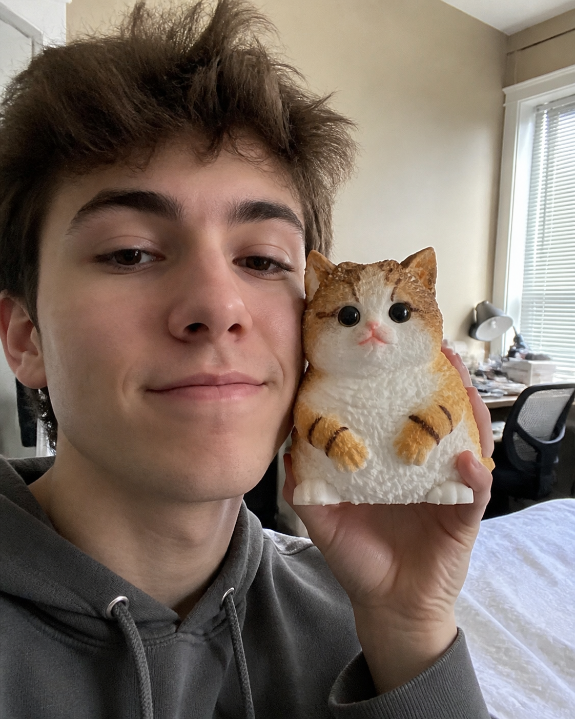 Casual customer selfie holding the exact orange Mochi Taba Cat beside his face.