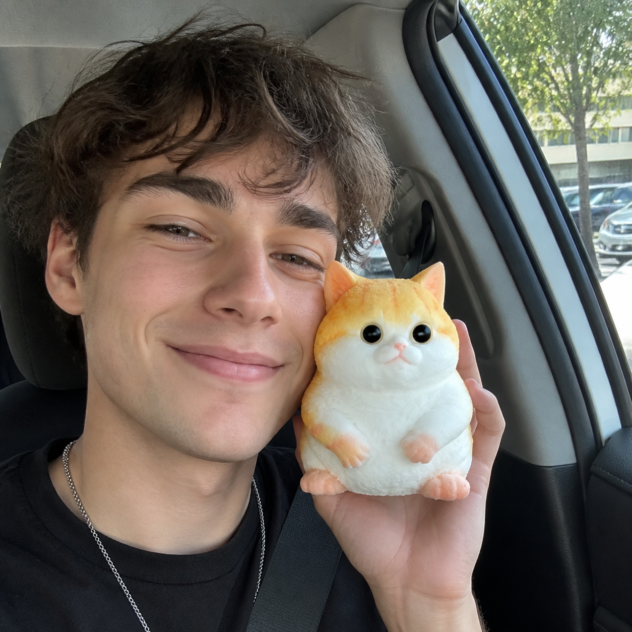 Casual car selfie with the exact orange chunky Taba cat squishy.