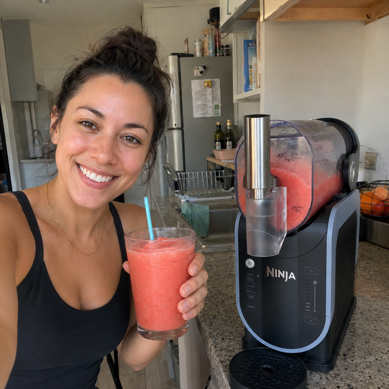 Customer-style kitchen photo holding a pink slush beside the Ninja SLUSHi.